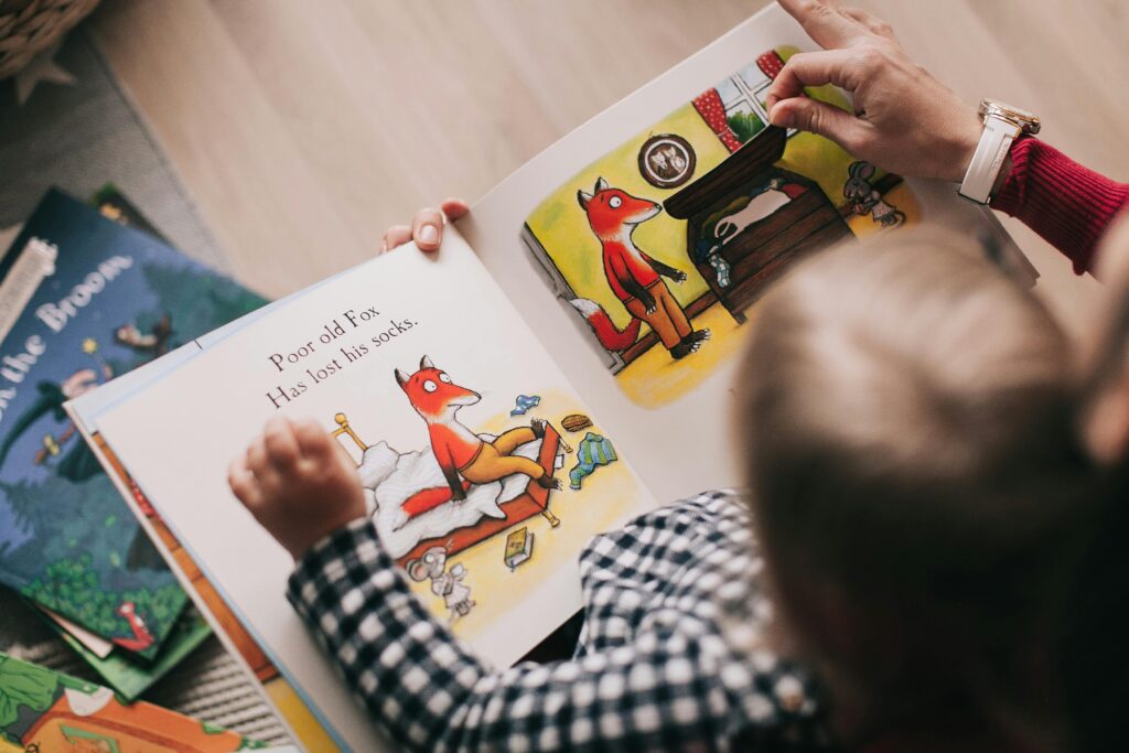 A child and adult reading an illustrated storybook together in a cozy setting.